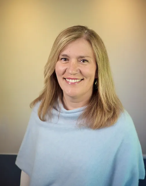 A woman with long hair is smiling for the camera.