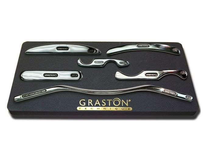 A set of six graston tools on top of a black tray.