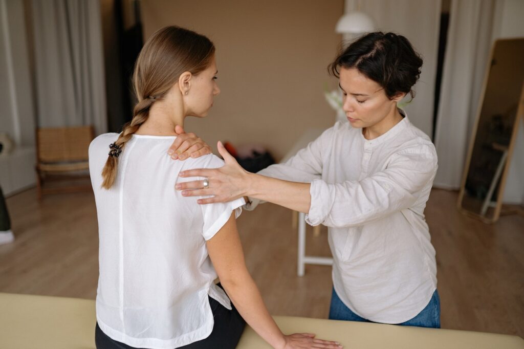 A woman is helping another person with her arm.