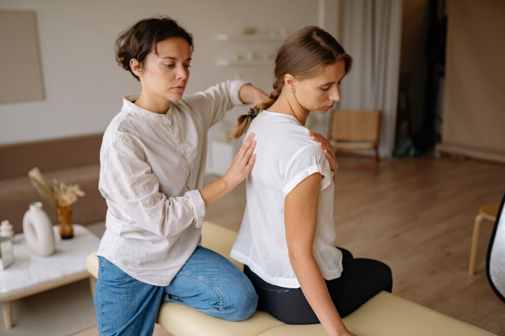 A woman is getting her neck adjusted by another person.