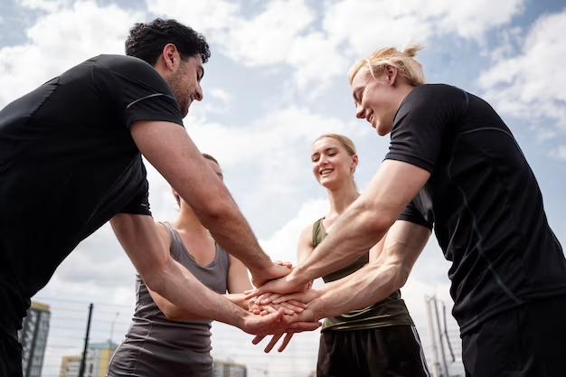 A group of people holding hands in the middle of a circle.